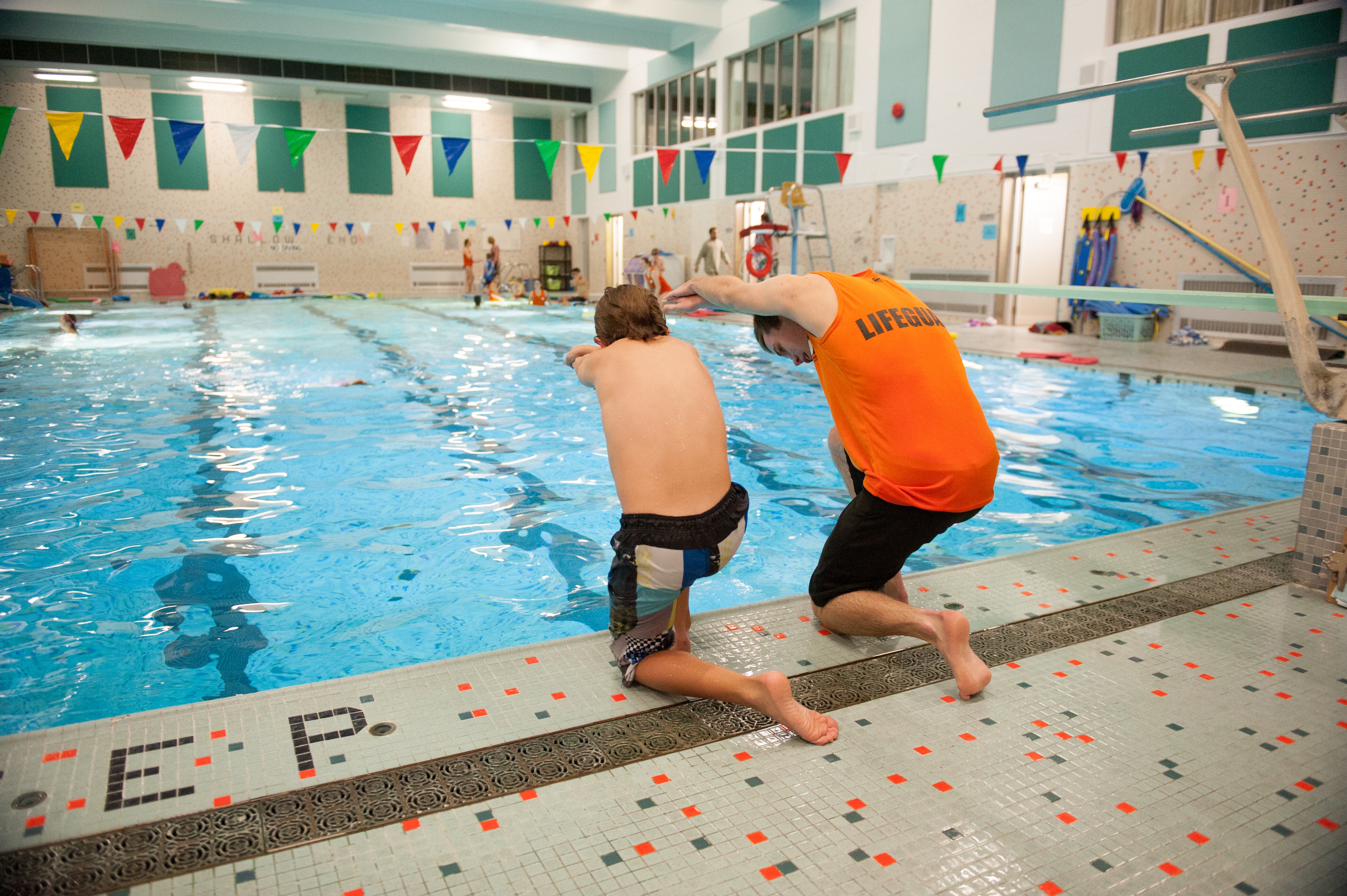 young boy and life guard getting ready to dive into pool