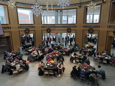 birdseye view of people sitting at numerous round tables indoors