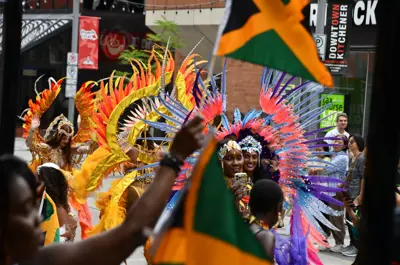 Revellers in colourful costumes walking down King Street