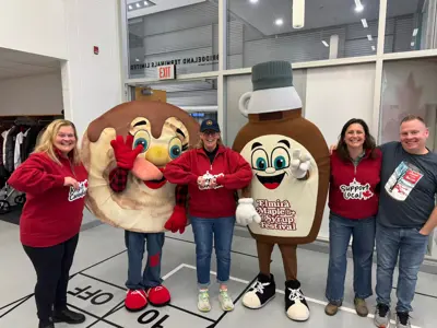 City councillors posing with mascots dressed as maple syrup