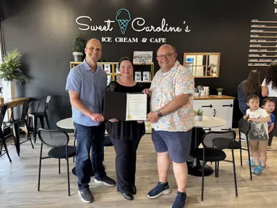 Mayor and councillor posing with bakery staff and certificate