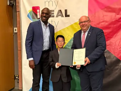 two adults with young child standing with a certificate