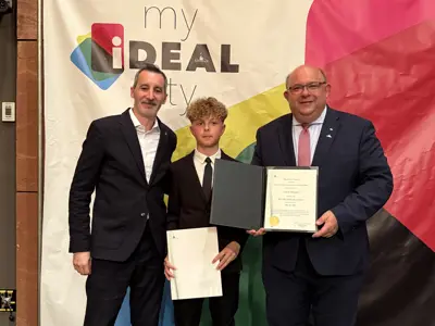 Mayor and councillor posing with youth and certificate for photo