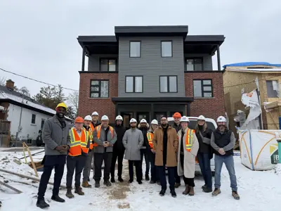 Mayor and council standing in front of house with hard hats on