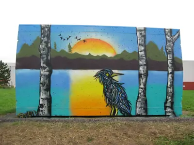 mural painted on side of shed with lake and setting sun with trees and a bird in the forefront