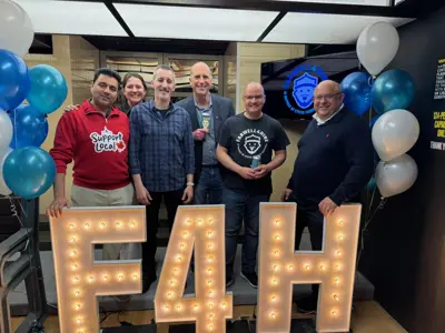 Mayor, council and members of public posing for photo infront of marquee letters