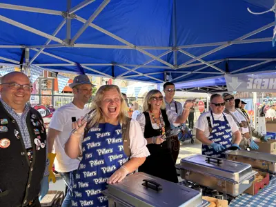 Mayor and council serving sausages at Oktoberfest