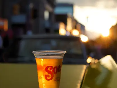 Cup of beer sitting on hood of car