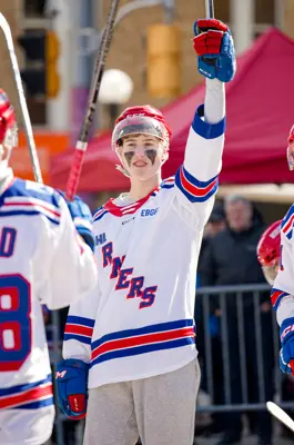 Kitchener Rangers player lifting his stick in the air in victory after scoring a goal