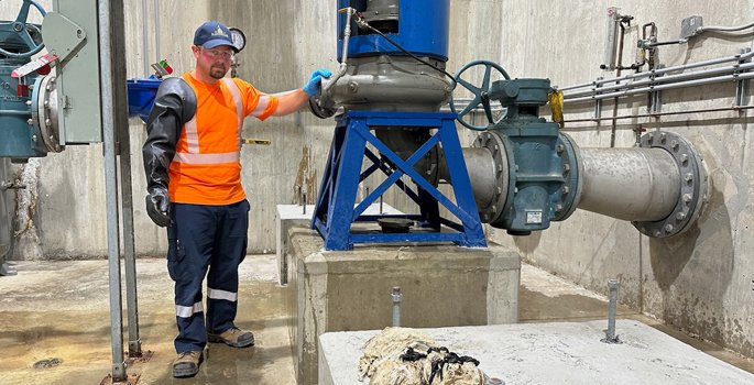 Staff person cleaning out sanitary system