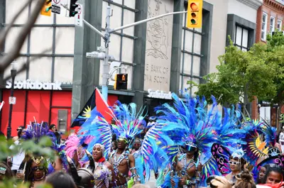 Revellers in colourful costumes walking down King Street